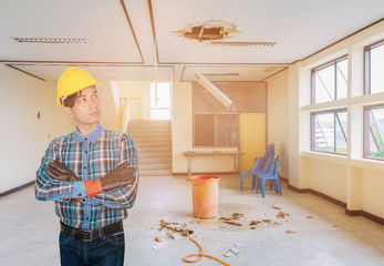 Engineer thinking water leak drop in office building repair from gypsum ceiling and flow on terrazzo floor