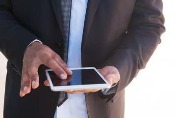 Businessman using tablet. Closeup of gadget in hands of man in jacket and tie. Communication concept