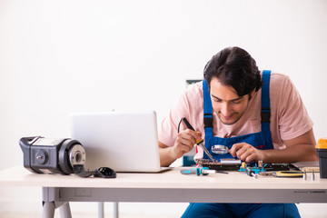 Obraz na płótnie Canvas Young male contractor repairing computer 