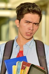 Young Asian Male Student And Confusion With Notebooks