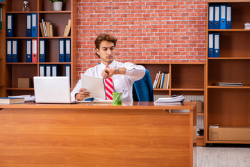 Young handsome employee sitting in the office  