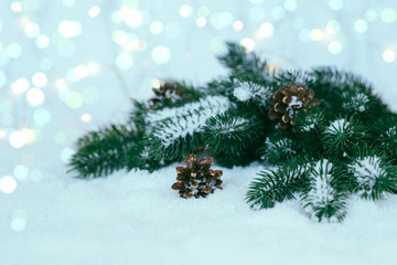Christmas light background with fir branches and snow with twinkling lights. Holiday mock up. Toned image with copy space. Selective focus.