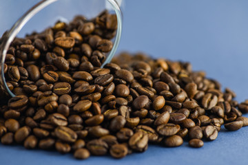 Scattered coffee beans on a blue background. Horizontal photography