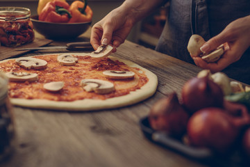 Food ingredients and spices for cooking pizza. Mushrooms, tomatoes, cheese, onion, oil, pepper, salt, basil, olive and delicious italian pizza on dark wooden background. Pizza menu. Homemade cooking.