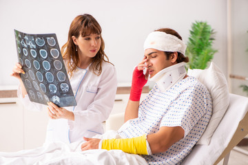 Obraz premium Young doctor examining injured patient 