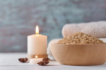 Spa and cosmetic treatment composition. Sea salt in bowl, burning candle and towels