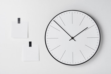 Round wall clock and two sticky on white background