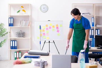 Male handsome professional cleaner working in the office 