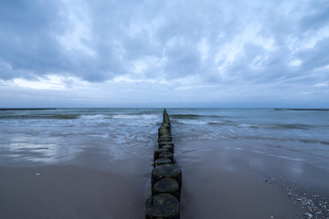 Sunset on the beach with waves against a dramatic blue cloudy sky, baltic sea, Usedom