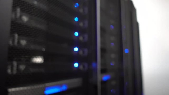 Data center, server room in a blurry background. Blinking blue led ligts. Handheld shooting, no stabilization.