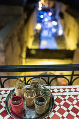 Night view of a tea set in a traditional coffeeshop with a street in the background