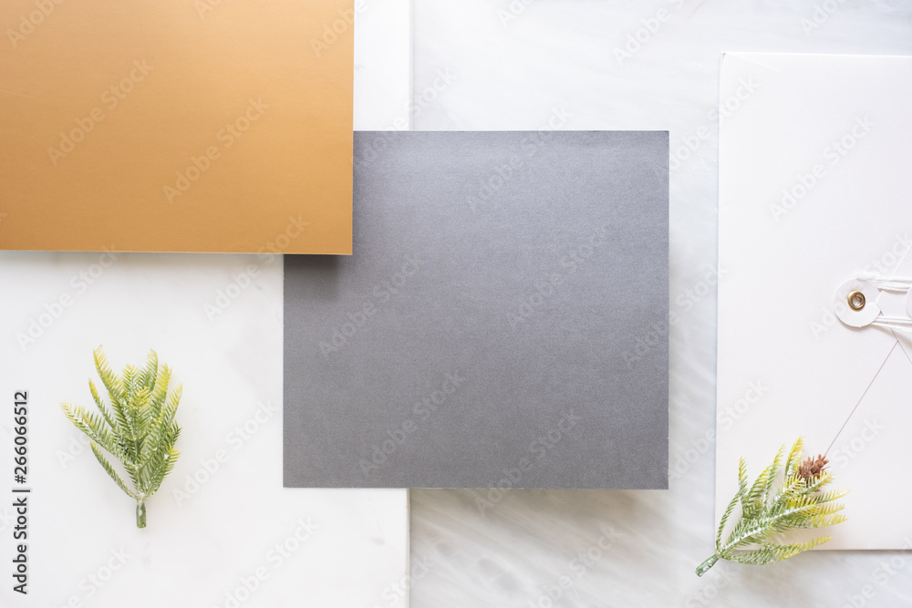 Poster Top view of blank grey card overlap on envelop and gold card with pine leaf on two layer step of marble table top.Mock up template for display of design .luxury business items