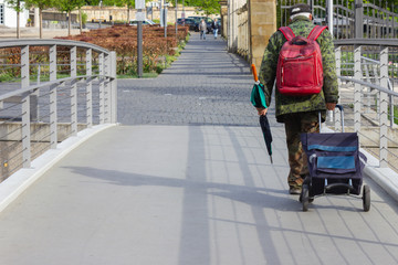 homeless person walking with trolley