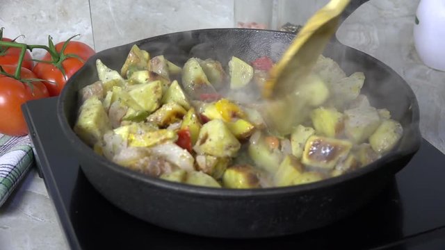 Saut&eacute;ing potato wedges with bell peppers and onions