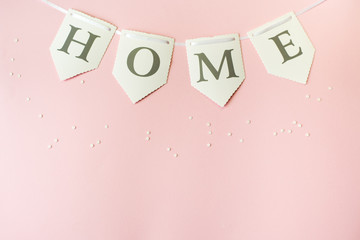 Word home on pastel pink background, top view with copy space . Family concept