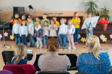 Performance by talented children. Children on stage perform in front of parents. image of blur kid 's show on stage at school , for background usage. Blurry