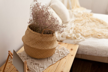Dry plants in a wicker basket adorn the vintage bedroom interior 