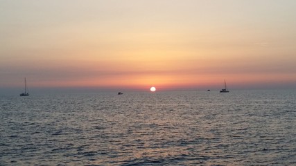 tramonto sul mare con barche sullo sfondo