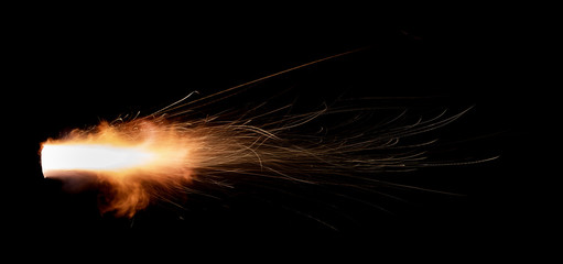 Texture of firearm shot with bright flash of light, sparks, smoke and gunpowder gases on black background