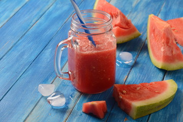 Fresh watermelon cocktail in glass on a blue wooden rustic background, copy space. Freshly blended summer watermelon smoothie