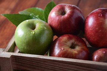 Fresh red and green apples in wooden box in rustic style. Healthy food 