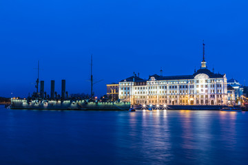 Petersburg, Russia - May 4 2019: Russian cruiser Aurora in the mouth of Neva river in Petersburg on the background of Nakhimov Naval School in the evening