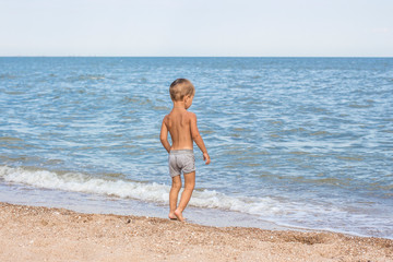 Fototapeta premium boy, sea, beach, water, little, summer, sand, swim, child, young, swimming, nature, kid, lifestyle, ocean, family, vacation, people, happy, fun, blue, leisure, sun, play, travel