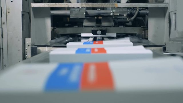 Many books moving on a conveyor in a print office, modern technology.