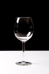 Red wine on a wineglass over a dark solid black background