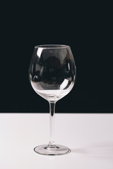 Red wine on a wineglass over a dark solid black background