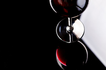 Red wine on a wineglass over a dark solid black background