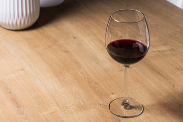Red wine on a wineglass over a wooden table
