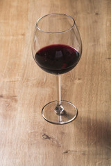 Red wine on a wineglass over a wooden table