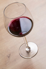 Red wine on a wineglass over a wooden table