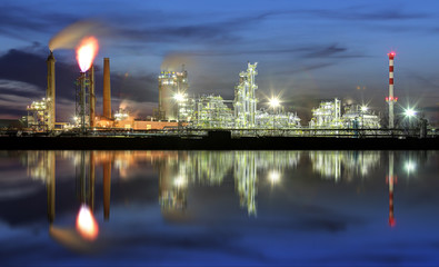 Fototapeta na wymiar Oil refinery at night with reflection in water