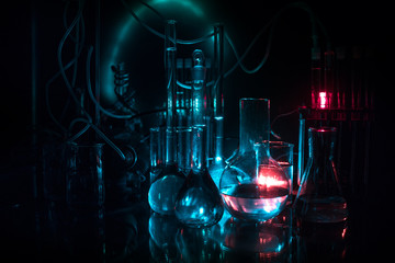 Pharmacy and chemistry theme. Test glass flask with solution in research laboratory. Science and medical background. Laboratory test tubes on dark toned background