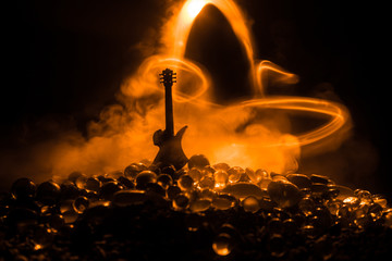 Music concept. Acoustic guitar isolated on a dark background under beam of light with smoke with...