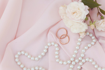 Obraz na płótnie Canvas Wedding rings on a pink silk background