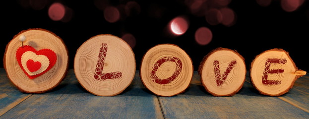  beautiful red heart is nailed to a wooden saw cut on a shiny background