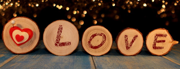  beautiful red heart is nailed to a wooden saw cut on a shiny background