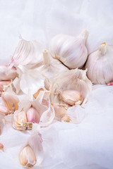 garlic, garlic cloves, garlic husks close-up on a white background with gauze
