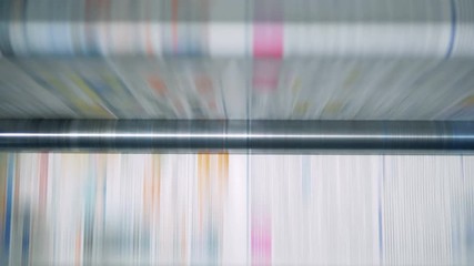 Rolling conveyor in work at a print office, printed paper.