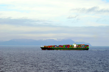 Big container ship, fully loaded with containers, sailing near Japanese island Hokkaido. 