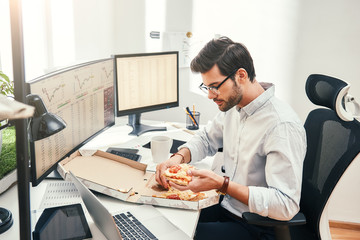 I love pizza! Young bearded businessman or trader in eyewear and formal clothes is eating hot pizza...