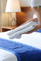Hands of hotel maid bringing fresh towels to the hotel room
