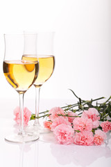 Two glasses with a drink and flowers on a white background