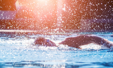 Young athletic man swimming in the swimming pool