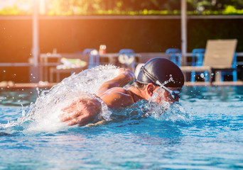 Young athletic man swimming in the swimming pool