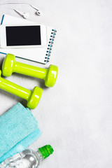 Dumbbells, measuring tape, water and apple top view.