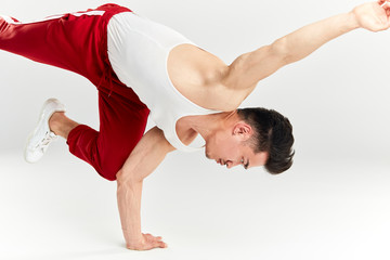 Hip hop male Korean break dancer dancing on white background, practicing shoulder freeze on floor.